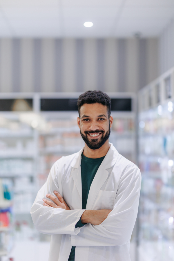 Portrait of young multiracial pharmacist looking at camera, standing in a pharmacy store.