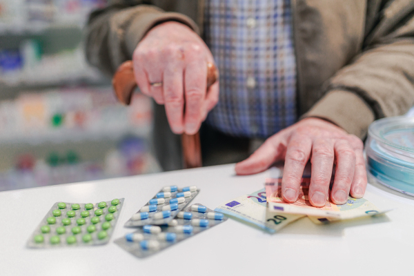 Close up of senior holding pills in a pharmacy store.