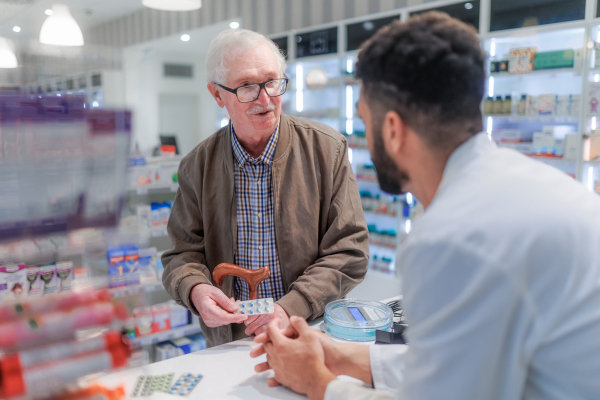 Young pharmacist explaining to customer how to dosing a medication.