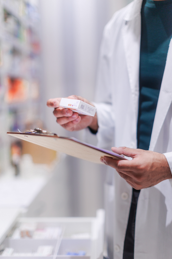 Pharmacist checking medicine stock in a pharmacy store.