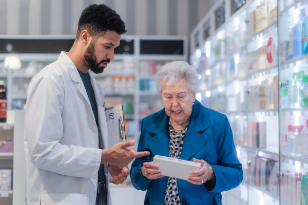 Young pharmacist helping senior woman to choos a medication.