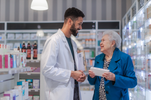 Young pharmacist helping senior woman to choos a medication.