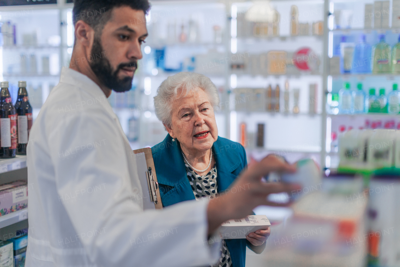 Young pharmacist helping senior woman to choos a medication.