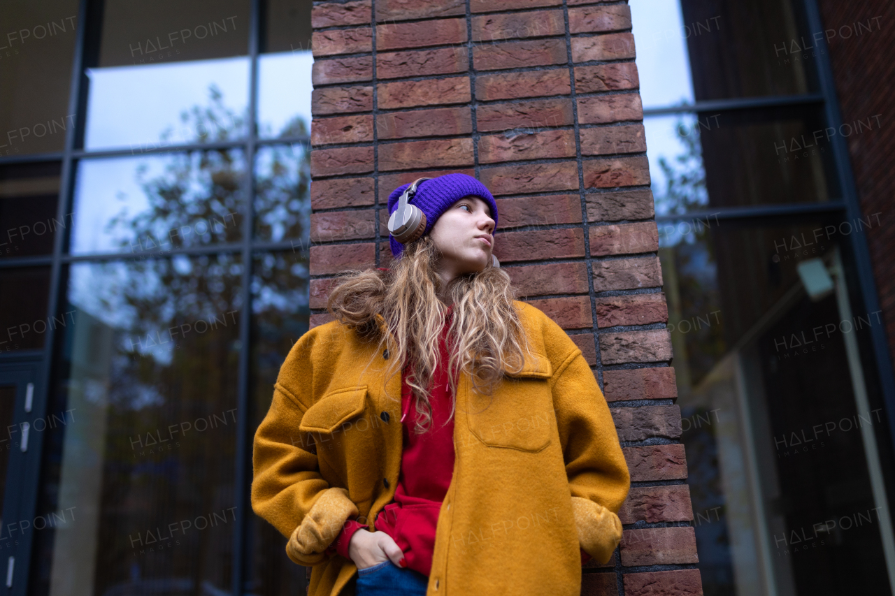 Young woman listening music outdoor, in city.