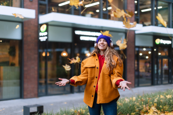 Young woman listening music outdoor, in city.