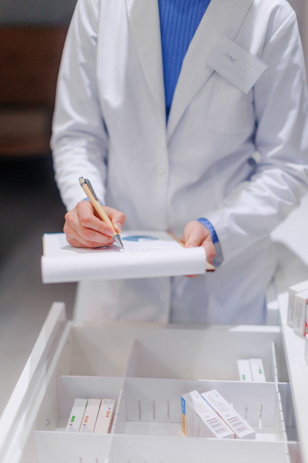 Pharmacist checking medicine stock in a pharmacy store.