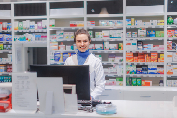 Portrait of a young pharmacist selling medication.