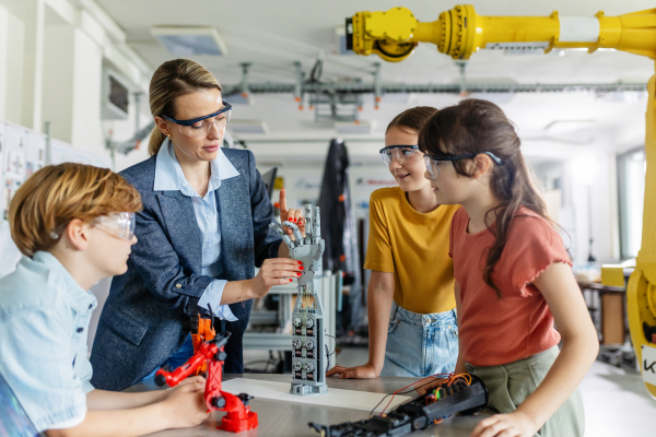 Children learning robotics in Elementary school. Young students building robot in after school robotics club. Field trip to real robotics laboratory.