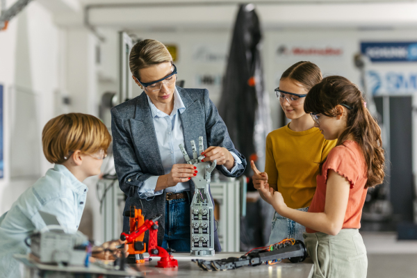 Children learning robotics in Elementary school. Young students building robot in after school robotics club. Field trip to real robotics laboratory.