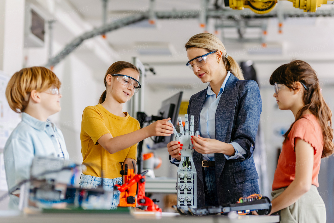 Children learning robotics in Elementary school. Young students building robot in after school robotics club. Field trip to real robotics laboratory.