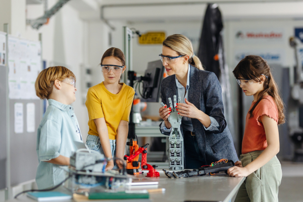 Children learning robotics in Elementary school. Young students building robot in after school robotics club. Field trip to real robotics laboratory.