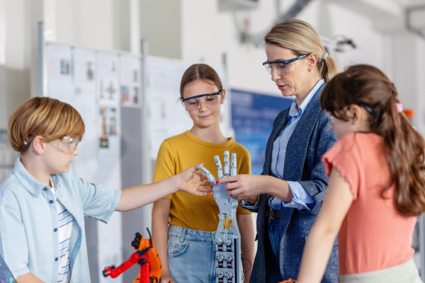 Children learning robotics in Elementary school. Young students building robot in after school robotics club. Field trip to real robotics laboratory.