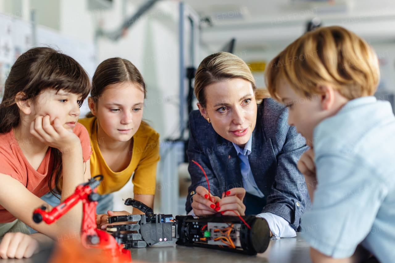 Children learning robotics in Elementary school. Young students building robot in after school robotics club. Field trip to real robotics laboratory.