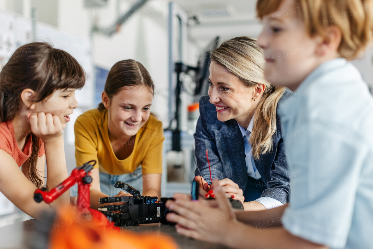 Children learning robotics in Elementary school. Young students building robot in after school robotics club. Field trip to real robotics laboratory.