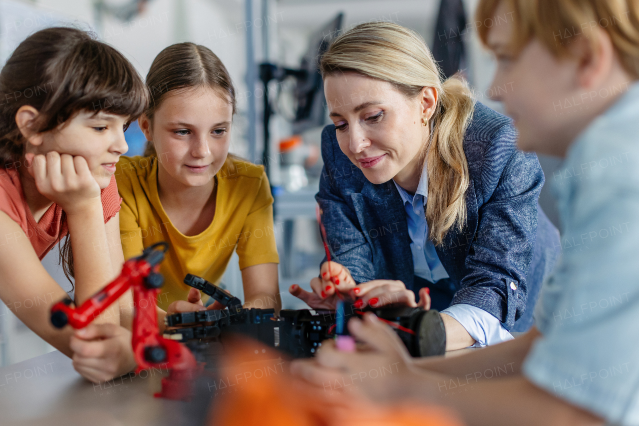 Children learning robotics in Elementary school. Young students building robot in after school robotics club. Field trip to real robotics laboratory.