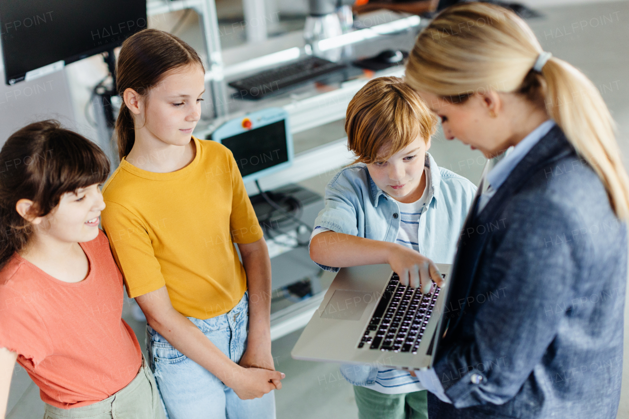 Children learning robotics in Elementary school. Young students building robot in after school robotics club. Field trip to real robotics laboratory.