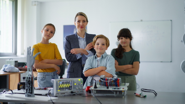 Children learning robotics in Elementary school. Young students building robot in after school robotics club. Field trip to real robotics laboratory.