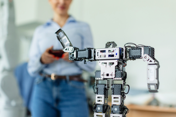 Teacher showing kids how small robot working. Children learning robotics, programming and engineering in school.