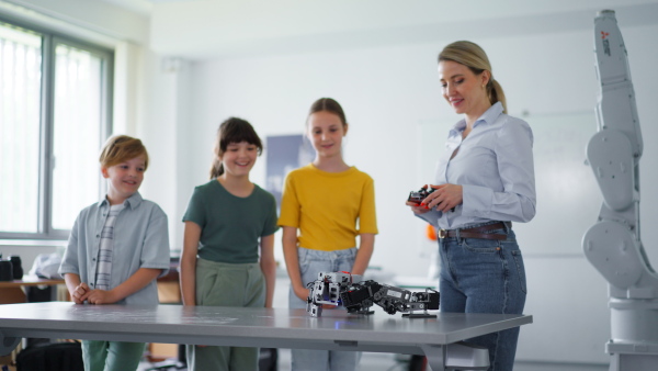 Children learning robotics in Elementary school. Young students building robot in after school robotics club. Field trip to real robotics laboratory.