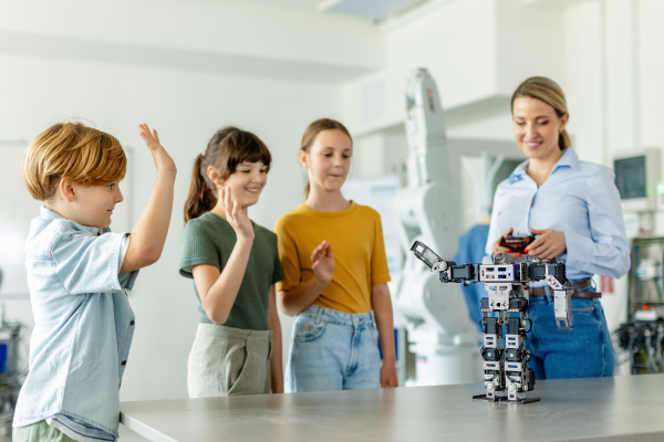 Children learning robotics in Elementary school. Young students building robot in after school robotics club. Field trip to real robotics laboratory.