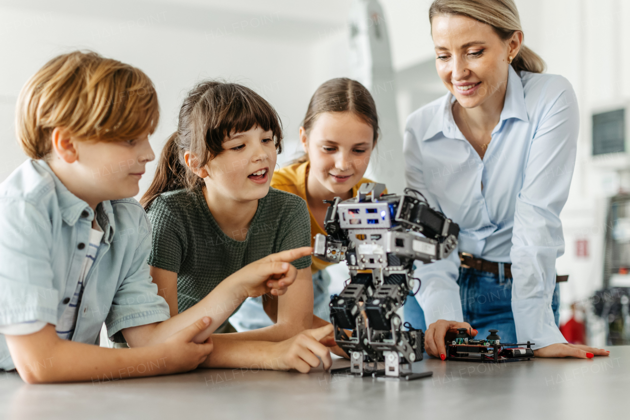 Children learning robotics in Elementary school. Young students building robot in after school robotics club. Field trip to real robotics laboratory.