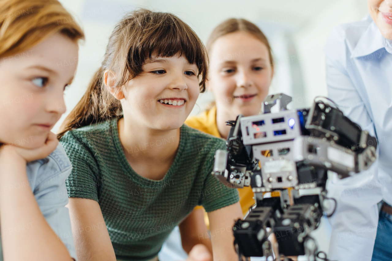 Children learning robotics in Elementary school. Young students building robot in after school robotics club. Field trip to real robotics laboratory.