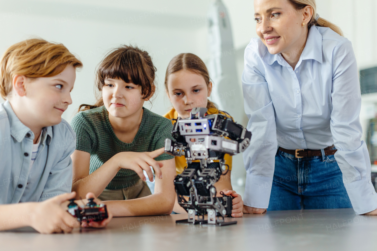 Children learning robotics in Elementary school. Young students building robot in after school robotics club. Field trip to real robotics laboratory.