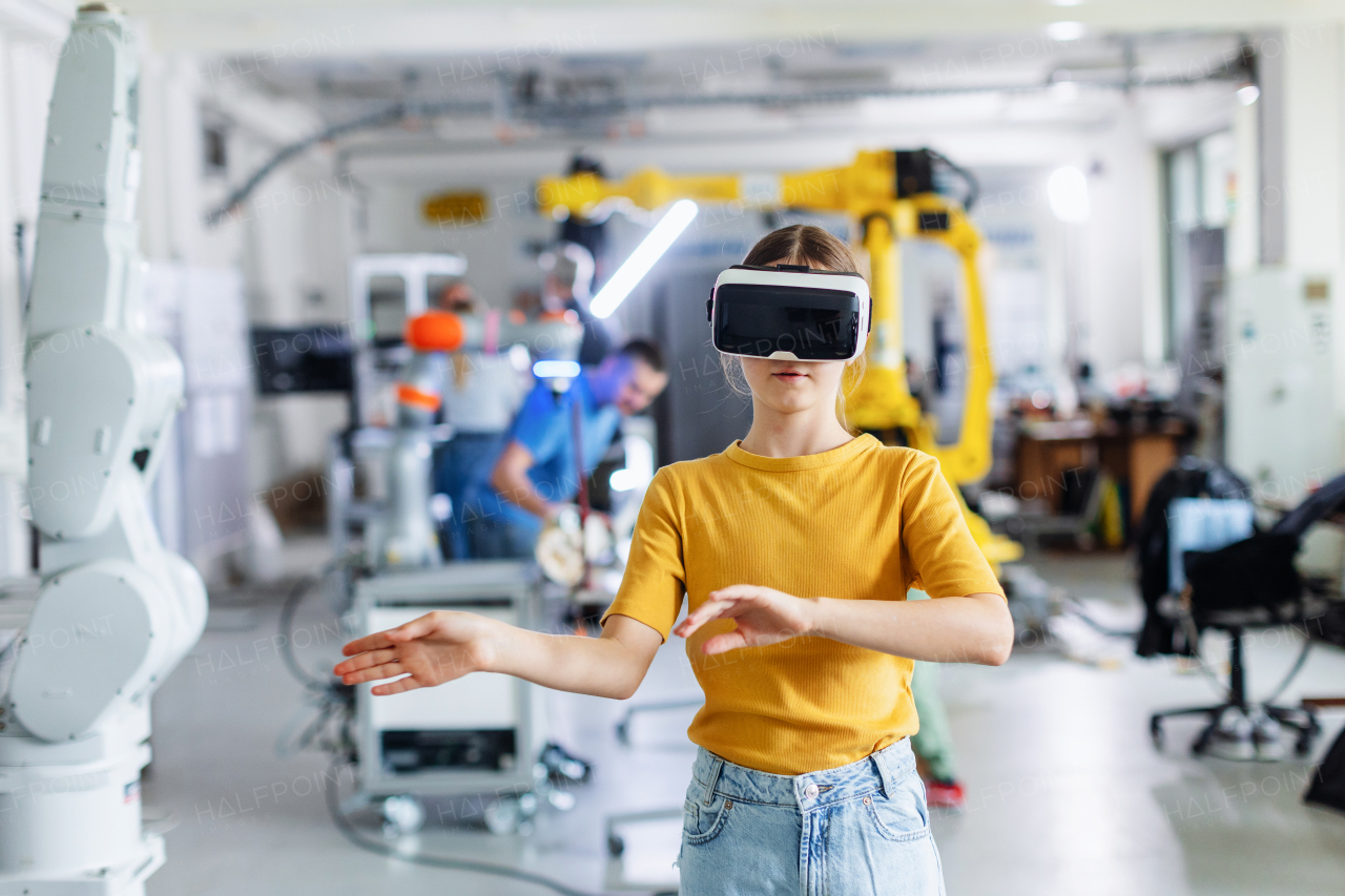 Portrait of schoolgirl with VR headset on head. Children learning robotics in Elementary school, using modern technology, virtual reality. Girls in science.