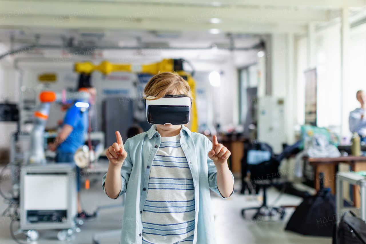 Portrait of schoolboy with VR headset on head. Children learning robotics in Elementary school, using modern technology, virtual reality. Girls in science.