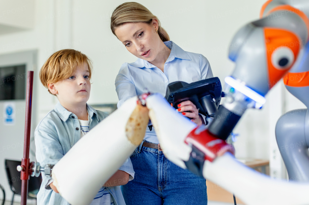 Mom and boy during take your kid to work day, encouraging children in career in robotics. Field trip to real robotics laboratory. Real scientist talking to schoolboy.