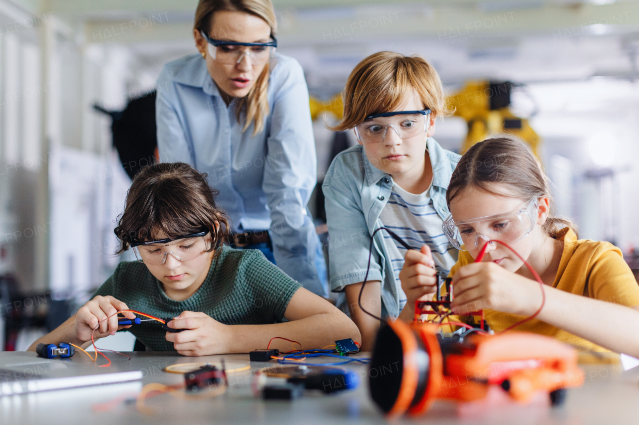 Children learning robotics in Elementary school. Young students building robot in after school robotics club