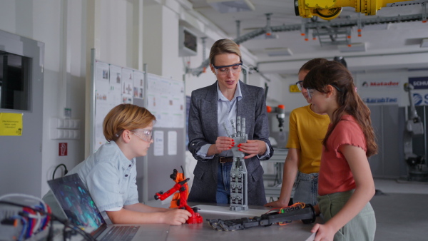 Children learning robotics in Elementary school. Young students building robot in after school robotics club. Field trip to real robotics laboratory.