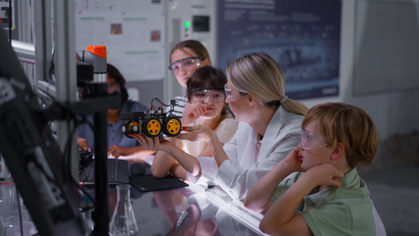 Children learning robotics in Elementary school. Young students building robot in after school robotics club. Field trip to real robotics laboratory.