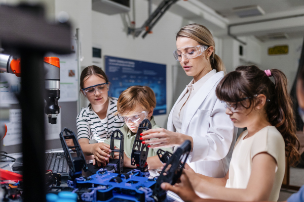 Children learning robotics in Elementary school. Young students programming, building robot in after school robotics club. Field trip to real robotics laboratory.