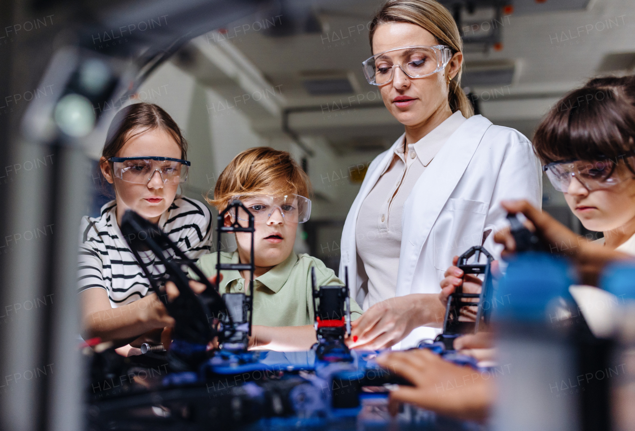 Children learning robotics in Elementary school. Young students building robot in after school robotics club