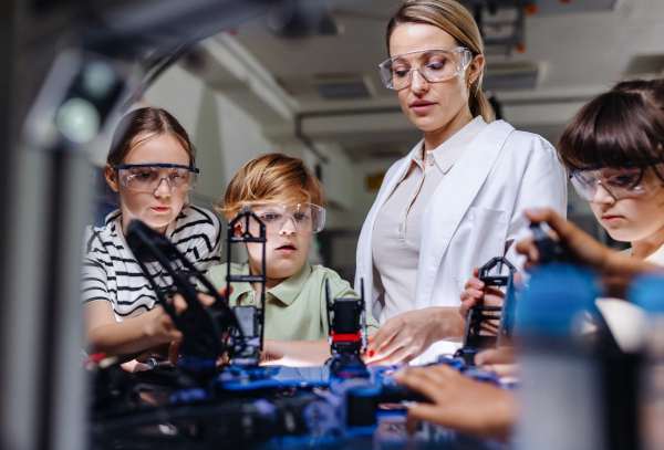 Children learning robotics in Elementary school. Young students building robot in after school robotics club