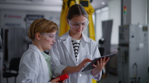 Mom and boy during take your kid to work day, encouraging children in career in robotics. Field trip to real robotics laboratory. Real scientist talking to schoolboy.