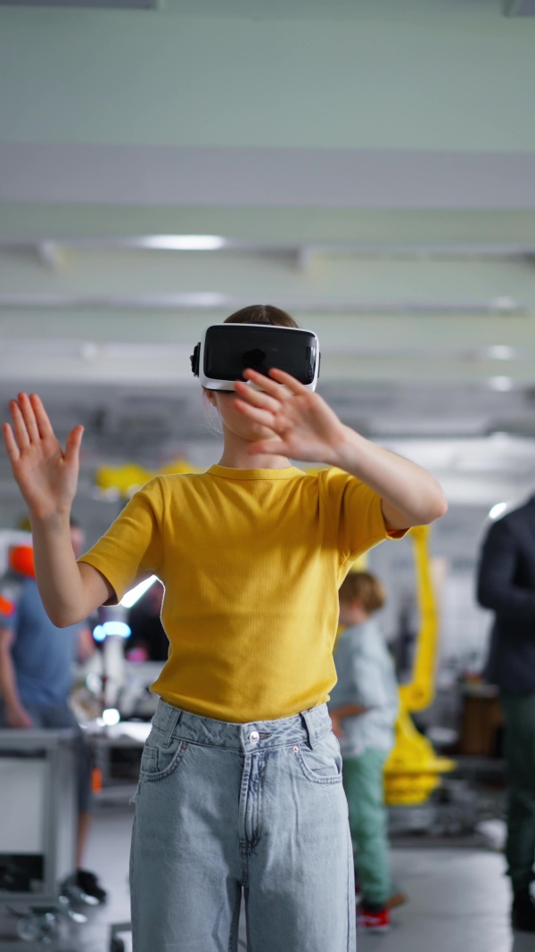 Video of schoolgirl with VR headset on head. Children learning robotics in Elementary school, using modern technology, virtual reality. Girls in science.