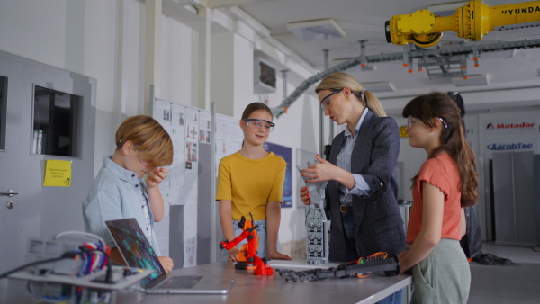 Children learning robotics in Elementary school. Young students building robot in after school robotics club. Field trip to real robotics laboratory.