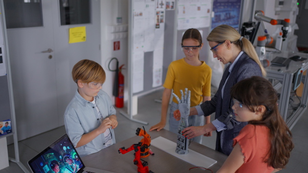 Children learning robotics in Elementary school. Young students building robot in after school robotics club. Field trip to real robotics laboratory.