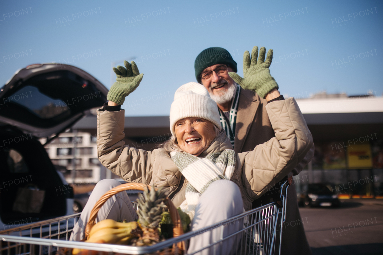 Senior couple going home from a grocery store, having fun.