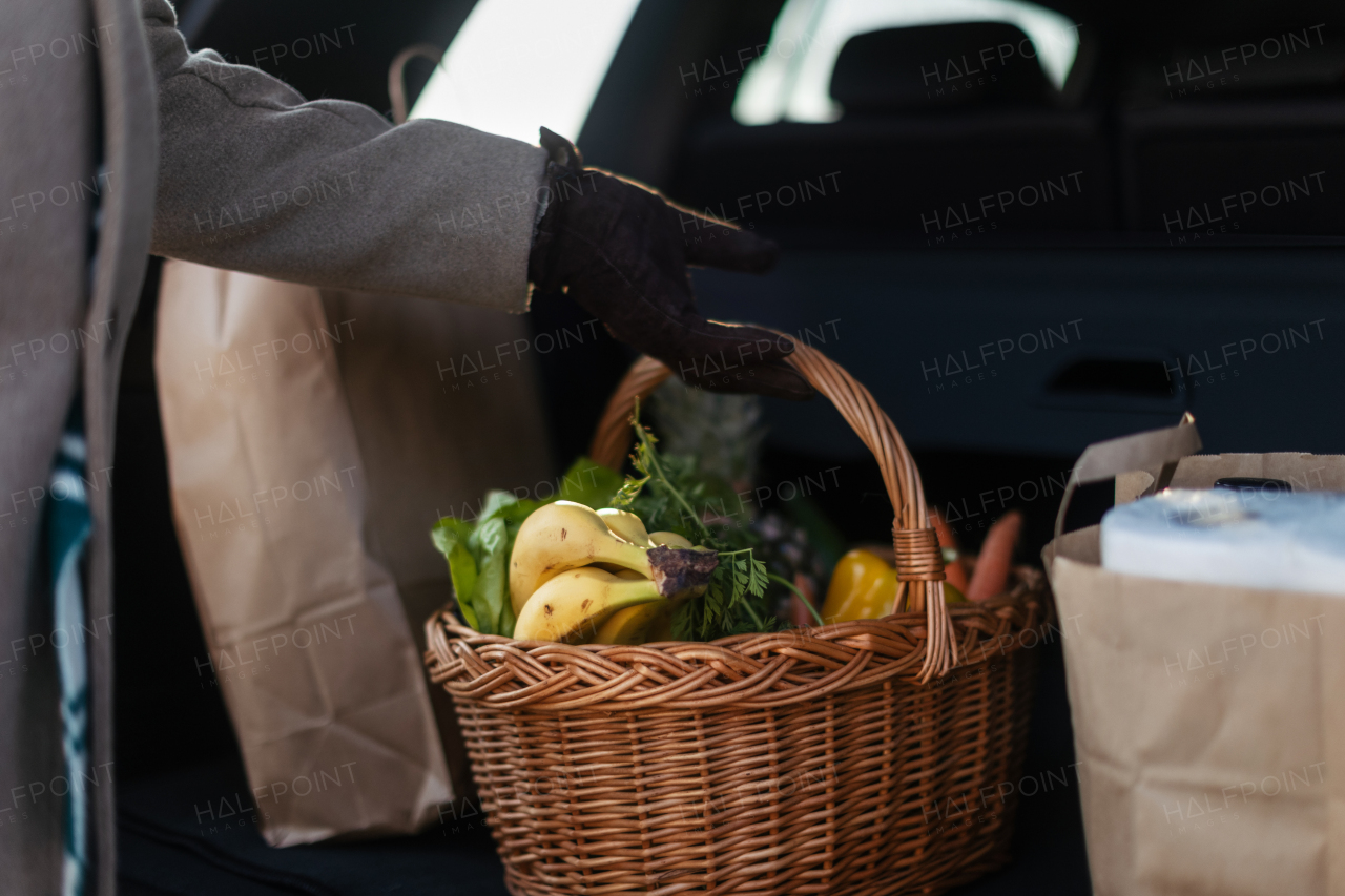 Close-up of somebody giving his purchase in the electric car trunk.