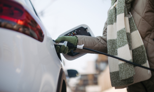 Close up of a unrecognizable woman charging electric car.