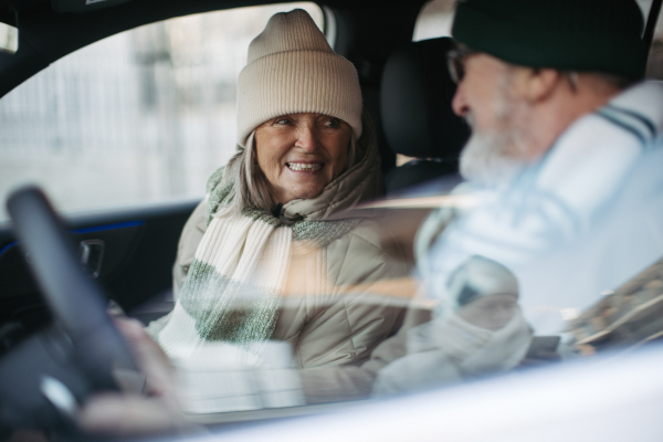 Senior couple sitting in the electric car.