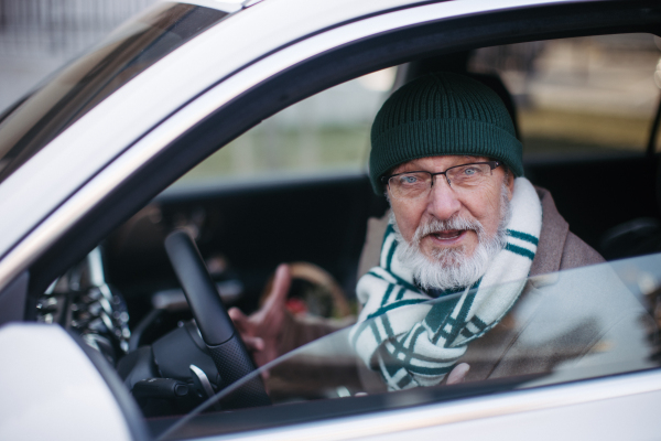 Angry senior man driving a car, close-up.