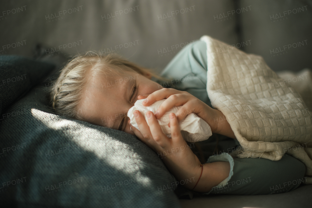 Sick little girl lying in the bed.