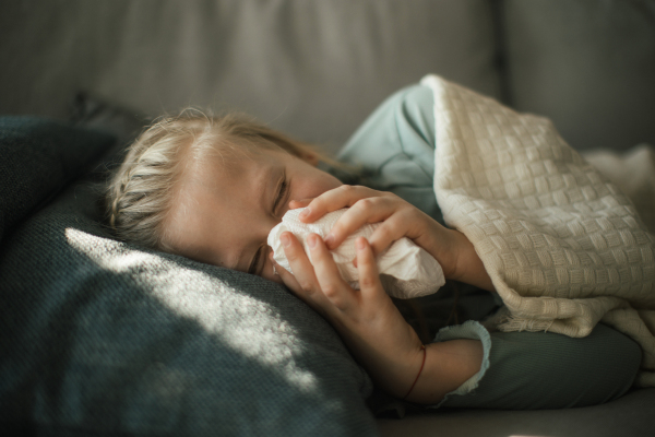 Sick little girl lying in the bed.