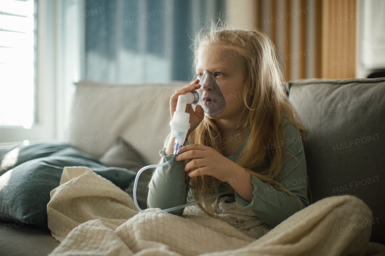 LIttle sick girl using an inhaler during flu.