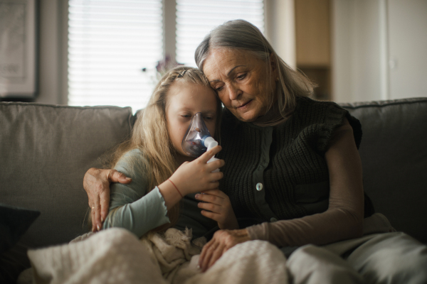 Senior woman taking care of sick granddaughter.