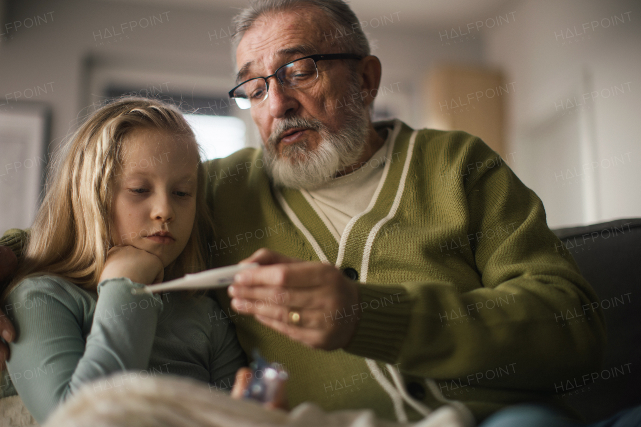 Senior man taking care of sick granddaughter.